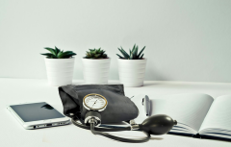 Stetoskop, Handy und Notizbuch am Arbeitsplatz